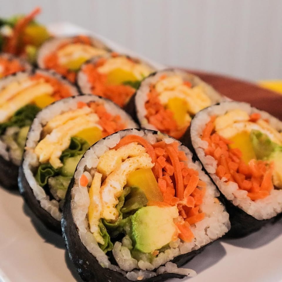 Close-up of J's Korean Food's gimbap rolls with egg, carrots, avocado, and lettuce.